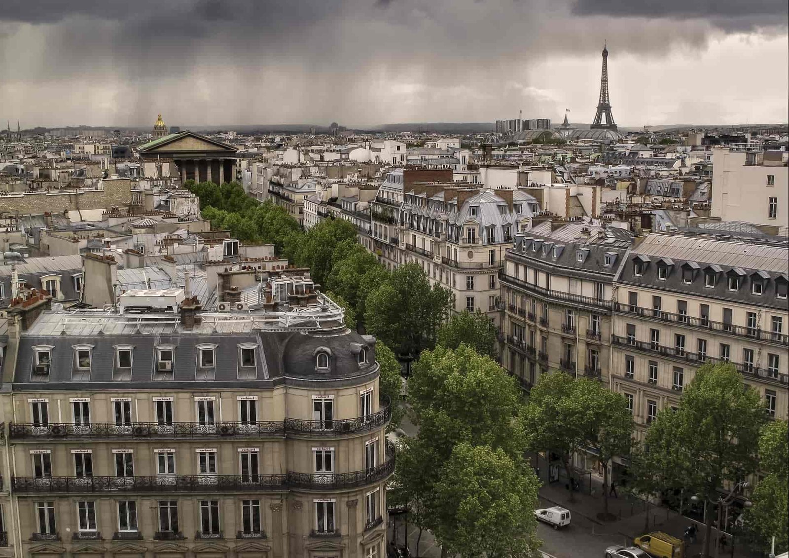 A photo of Paris, France, with the Eiffel Tower in the background. There are many buildings and trees in the foreground