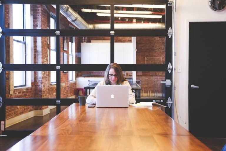 A girl working on her laptop sitting on a desk