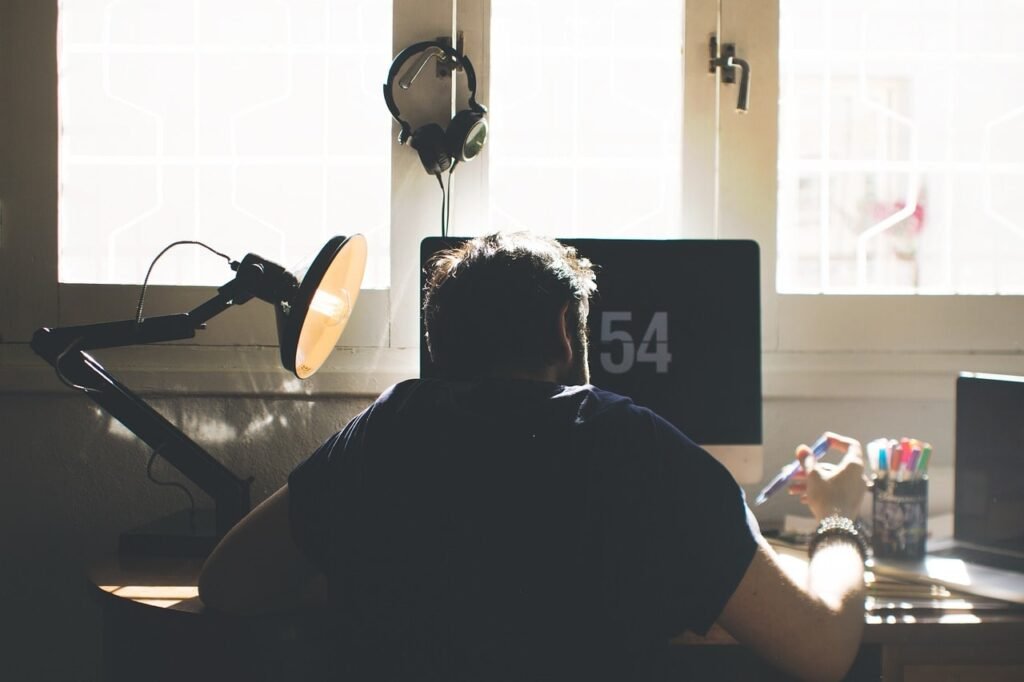 a man working on his computer in the early morning